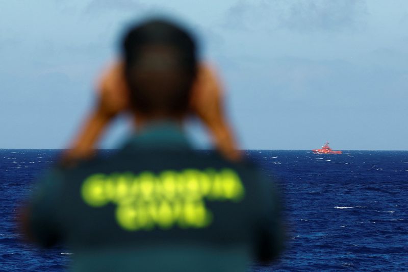 © Reuters. A Civil Guard officer watches a rescue boat searching for possible survivors after the sinking of a wooden boat with migrants near the port of La Restinga, on the island of El Hierro, Spain, September 28, 2024. REUTERS/Borja Suarez