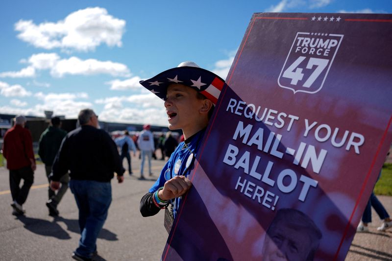 &copy; Reuters. FILE PHOTO: A person holds a sign asking people to request their mail-in ballot, on the day of Republican presidential nominee and former U.S. President Donald Trump's rally, in Mosinee, Wisconsin, U.S. September 7, 2024. REUTERS/Brian Snyder/File Photo