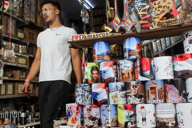 © Reuters. A man walks past mugs featuring  pictures of Syrian President Bashar al-Assad and Lebanon's Hezbollah leader Sayyed Hassan Nasrallah, who was killed in an Israeli airstrike on Friday, at a souvenir shop during national mourning for Nasrallah, in Damascus, Syria, September 29, 2024. REUTERS/Firas Makdesi