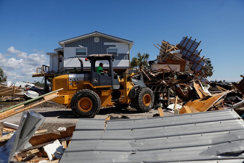 © Reuters. A man operating a front loader clears a home from the road that was destroyed in Keaton Beach after Hurricane Helene passed through the Florida panhandle, severely impacting the community in Keaton Beach, Florida, U.S., September 29, 2024. REUTERS/Octavio Jones