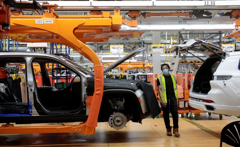 &copy; Reuters. A Stellantis assembly worker walks between two 2021 Jeep Grand Cherokee L vehicles on the assembly line at the Detroit Assembly Complex - Mack Plant in Detroit, Michigan, U.S., June 10, 2021. REUTERS/Rebecca Cook/File Photo