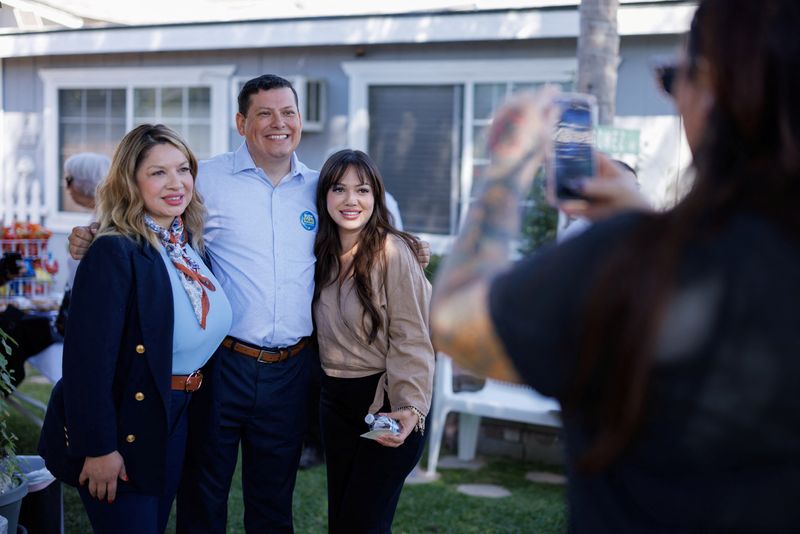 © Reuters. Democrat candidate Rudy Salas poses for a picture with supporters during a backyard gathering in California's 22nd congressional district in Corcoran, California, U.S. September 21, 2024. REUTERS/Mike Blake