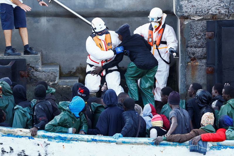 © Reuters. Rescuers help a migrant to disembark at the port of La Restinga on the island of El Hierro, Spain, September 30, 2024. REUTERS/Borja Suarez