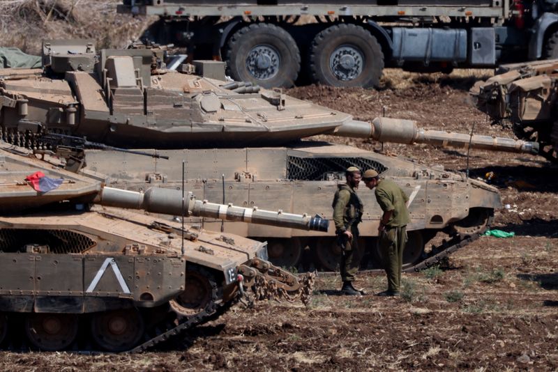 &copy; Reuters. Israeli members of the military stand next to armoured vehicles, amid cross-border hostilities between Hezbollah and Israel, in northern Israel, September 30, 2024. REUTERS/Jim Urquhart