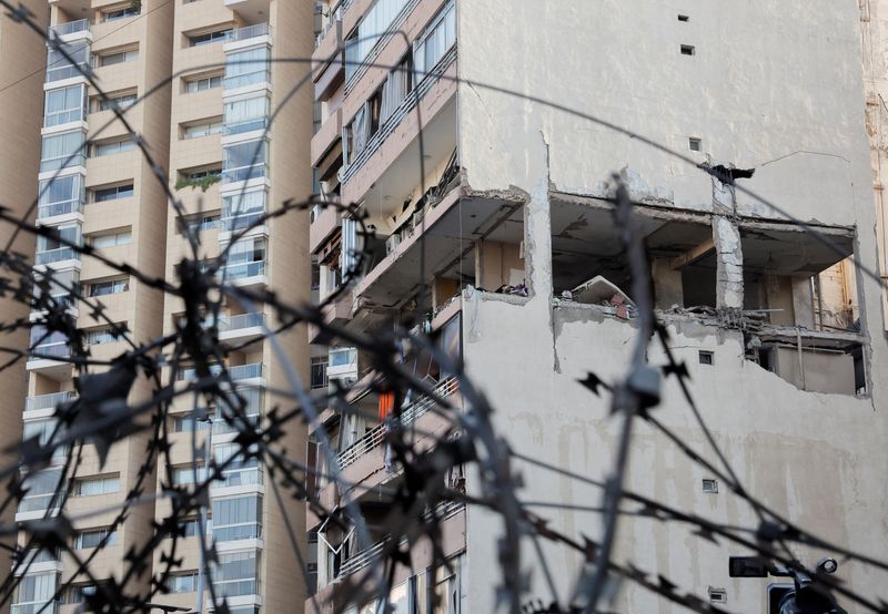 © Reuters. A building damaged in an Israeli strike is seen through a razor wire fence, amid ongoing cross-border hostilities between Hezbollah and Israeli forces, in Kola, central Beirut, Lebanon September 30, 2024. REUTERS/Louisa Gouliamaki