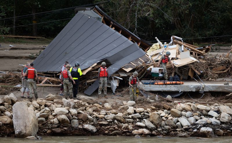 © Reuters. FILE PHOTO: People and a dog are escorted to a rescue boat in Chimney Rock, North Carolina, U.S., September 29, 2024. Khadejeh Nikouyeh/The Charlotte Observer/Handout via REUTERS/File Photo