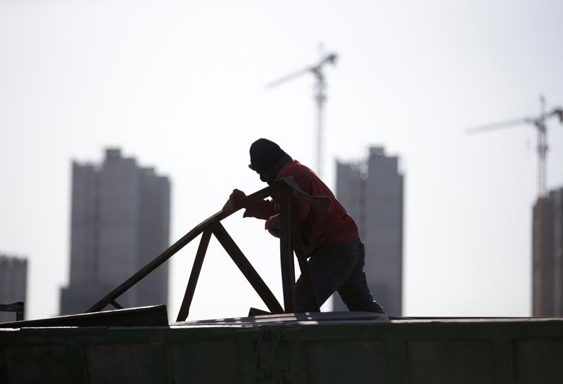 &copy; Reuters. FILE PHOTO: A man works near apartment blocks under construction on the outskirts of Beijing, China December 16, 2017. Picture taken December 16, 2017. REUTERS/Jason Lee/File Photo