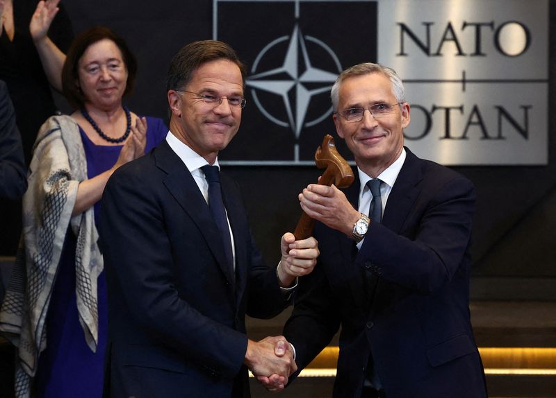 © Reuters. Jens Stoltenberg shakes hands with the new NATO Secretary General Mark Rutte, at a meeting of the North Atlantic Council, at the Alliance headquarters in Brussels, Belgium October 1, 2024. REUTERS/Yves Herman