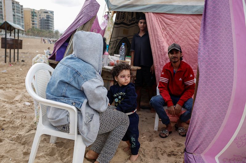 &copy; Reuters. Una famiglia siriana si ripara in un accampamento di fortuna dove vivono decine di sfollati, nel contesto delle ostilità tra Hezbollah e le forze israeliane, su una spiaggia di Beirut, in Libano, il 1° ottobre 2024. REUTERS/Louisa Gouliamaki