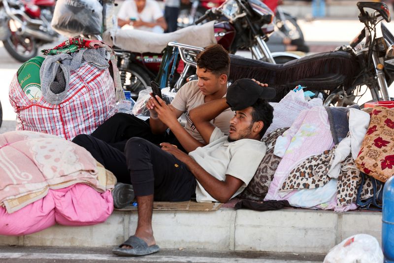 © Reuters. FILE PHOTO: Syrian refugees, who fled from southern Lebanon villages due to ongoing hostilities between Hezbollah and Israeli forces, take shelter in a parking lot in Sidon, Lebanon September 30, 2024. REUTERS/Aziz Taher/File Photo