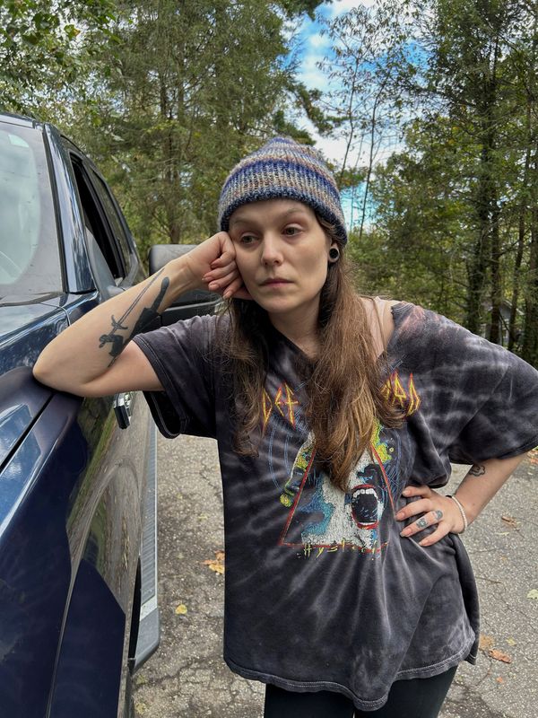 © Reuters. Jessica Dixon leans against a vehicle as she awaits news on her grandfather, who went missing after stormwaters from former Hurricane Helene tore through the creek behind her home, in Swannanoa, North Carolina, U.S., October 1, 2024. REUTERS/Bernie Woodall  