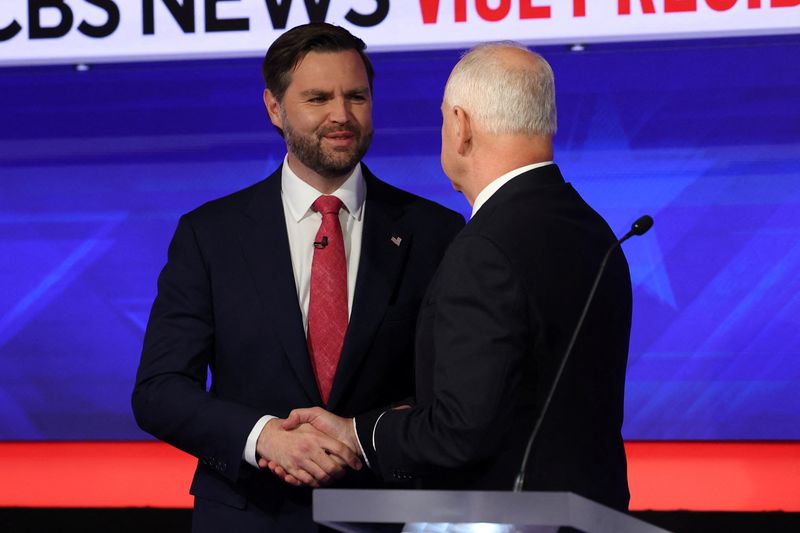 © Reuters. Democratic vice presidential nominee Minnesota Governor Tim Walz and Republican vice presidential nominee U.S. Senator JD Vance (R-OH) shake hands as they attend a debate hosted by CBS in New York, U.S., October 1, 2024. REUTERS/Mike Segar