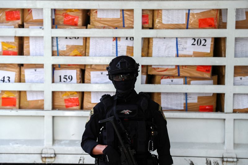 © Reuters. FILE PHOTO: A police officer from the Narcotics Control Board stands guard in front of boxes of confiscated drugs during the 50th Destruction of Confiscated Narcotics ceremony in Ayutthaya province, Thailand, June 26, 2020. REUTERS/Athit Perawongmetha/File Photo