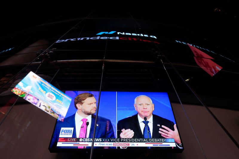 © Reuters. A screen shows the U.S. Vice Presidential debate between Republican vice presidential nominee Senator JD Vance (R-OH) and Democratic vice presidential nominee, Minnesota Governor Tim Walz,  outside the Nasdaq MarketSite in New York City, U.S., October 1, 2024. REUTERS/Adam Gray