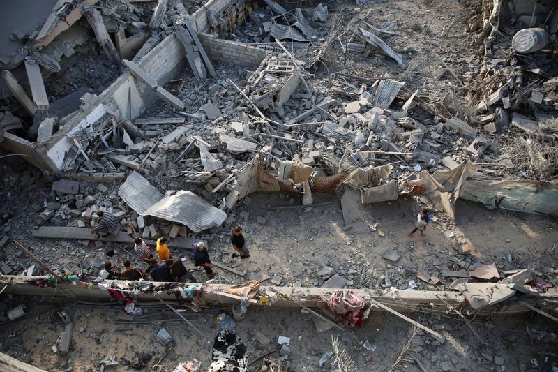 © Reuters. Palestinians inspect the site of Israeli strikes on houses, amid the Israel-Hamas conflict, in Khan Younis in the southern Gaza Strip, October 2, 2024. REUTERS/Hatem Khaled