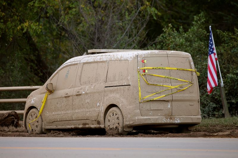 &copy; Reuters. A mud encrusted vehicle sits abandoned by the side of a road next to a U.S. flag in the aftermath of Hurricane Helene, in Candler, North Carolina, U.S. October 1, 2024.  REUTERS/Jonathan Drake