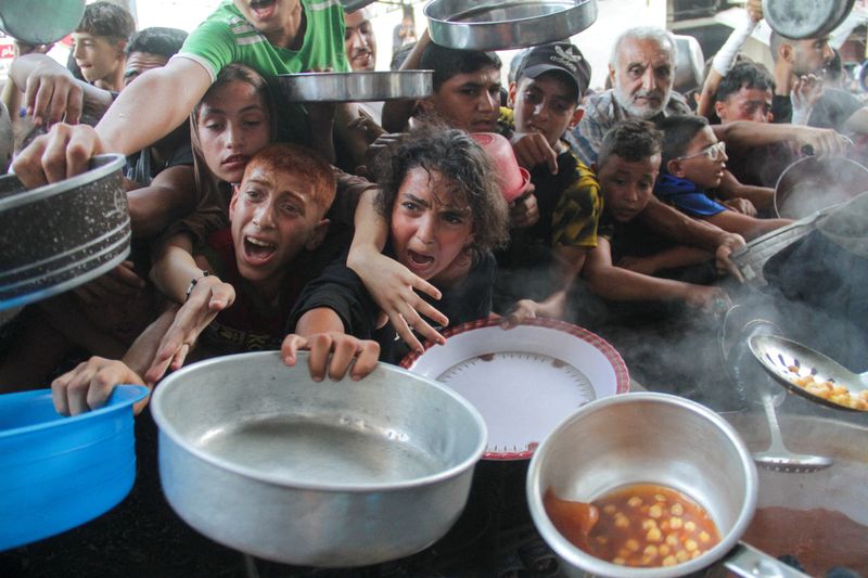 © Reuters. FILE PHOTO: Palestinians gather to receive food cooked by a charity kitchen, amid the Israel-Hamas conflict, in the northern Gaza Strip, September 11, 2024. REUTERS/Mahmoud Issa/File Photo