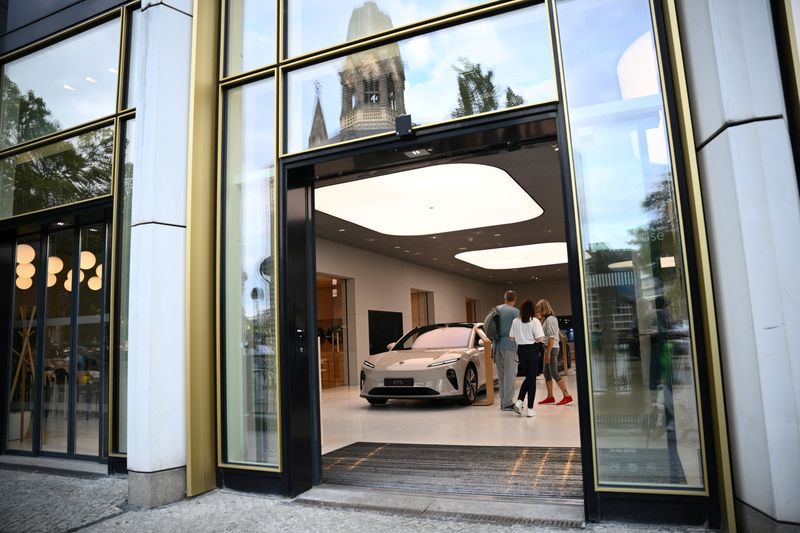 © Reuters. FILE PHOTO: People stand near NIO ET5 car model at the NIO House, the showroom of the Chinese premium smart electric vehicle manufacture NIO Inc. in Berlin, Germany August 17, 2023. REUTERS/Annegret Hilse/File Photo