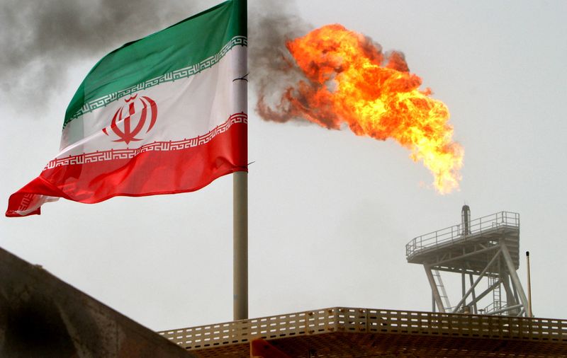 © Reuters. FILE PHOTO: A gas flare on an oil production platform is seen alongside an Iranian flag in the Gulf July 25, 2005. REUTERS/Raheb Homavandi/File Photo/File Photo