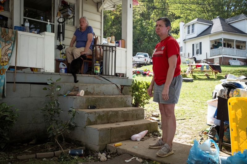 © Reuters. Ashley Wells stands outside her house following the passing of Hurricane Helene, in Canton, North Carolina, U.S., October 2, 2024. REUTERS/Marco Bello