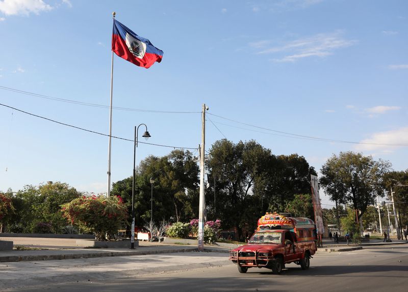 © Reuters. FILE PHOTO: A vehicle drives past Haiti's national flag, in Port-au-Prince, Haiti February 9, 2021. REUTERS/Valerie Baeriswyl/File Photo