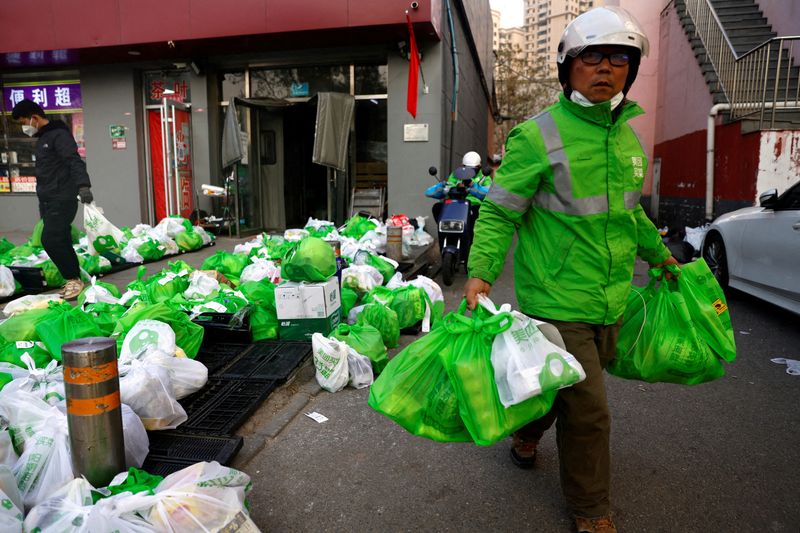 © Reuters. FILE PHOTO: A delivery worker picks up goods at a logistics station of online grocery platform Meituan in Beijing, China November 23, 2022. REUTERS/Tingshu Wang/File Photo