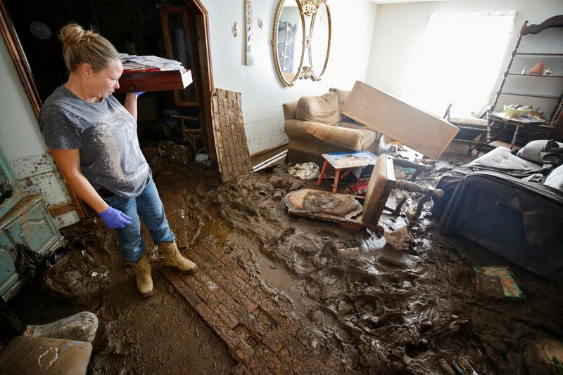 &copy; Reuters. FILE PHOTO: Sabra English pauses to survey a mud-strewn living room in her father's badly flooded home following Hurricane Helene, in Barnardsville, North Carolina, U.S. October 2, 2024.  REUTERS/Jonathan Drake /File Photo