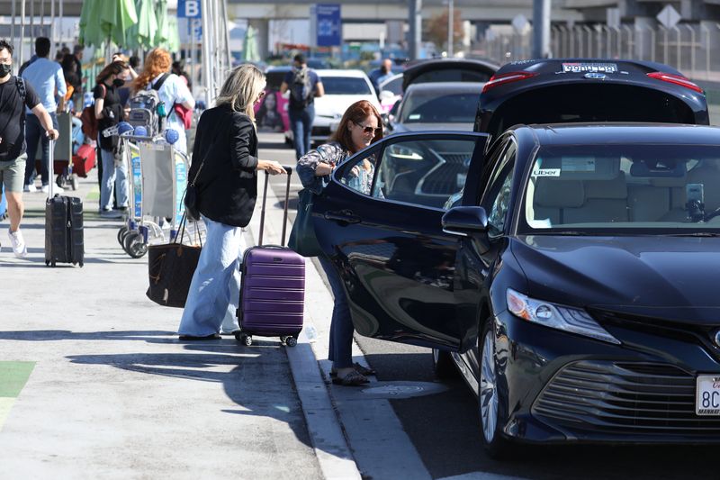 © Reuters. FILE PHOTO: Passengers board Uber ride-share cars after arriving at Los Angeles International Airport (LAX) in Los Angeles, California, U.S. July 10, 2022.  REUTERS/David Swanson/File Photo