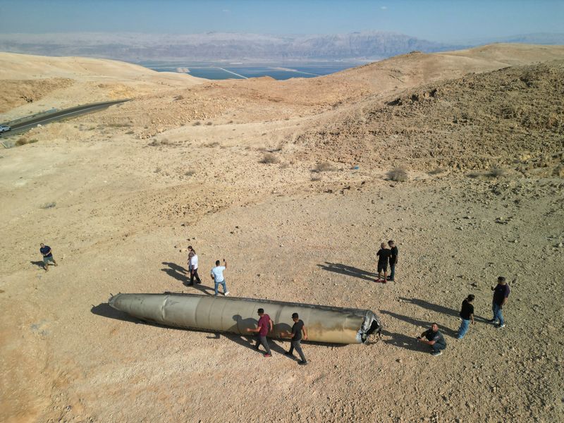 © Reuters. FILE PHOTO: A drone view shows people stand around apparent remains of a ballistic missile lying in the desert, following an attack by Iran on Israel, near the southern city of Arad, Israel October 2, 2024. REUTERS/Amir Cohen/File Photo