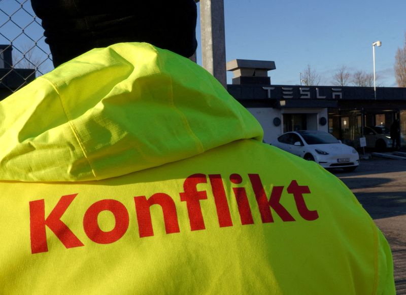 &copy; Reuters. FILE PHOTO: A member of IF Metall stands outside a Tesla showroom as workshop workers at the electric car company have gone on strike demanding the company sign a collective agreement, in Malmo, Sweden, December 14, 2023. REUTERS/Tom Little//File Photo