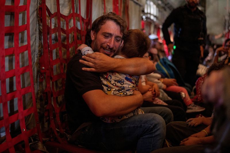 &copy; Reuters. Un padre abbraccia il figlio mentre cittadini greci e greco-ciprioti vengono evacuati dal Libano a bordo di un C130 dell'aeronautica militare ellenica, a causa delle ostilità in corso tra Hezbollah e le forze israeliane, a Beirut, in Libano, il 3 ottobre