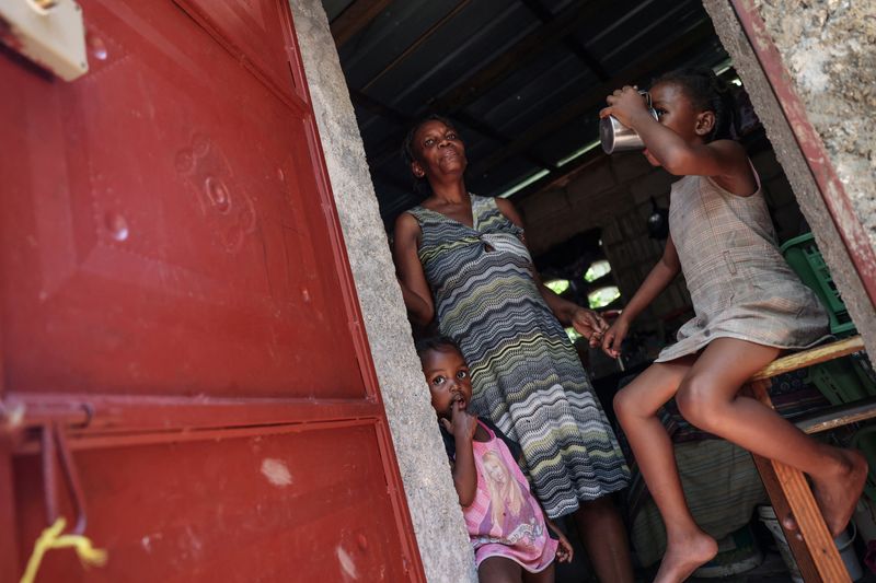 &copy; Reuters. FILE PHOTO: Rita Losandieu, 53, stands in front of her house with her two granddaughters Solius, 4, and Alisha, 6, in the Monoville area of the Juvenat neighbourhood in Port-au-Prince, Haiti, May 7, 2024. REUTERS/Ricardo Arduengo/File Photo