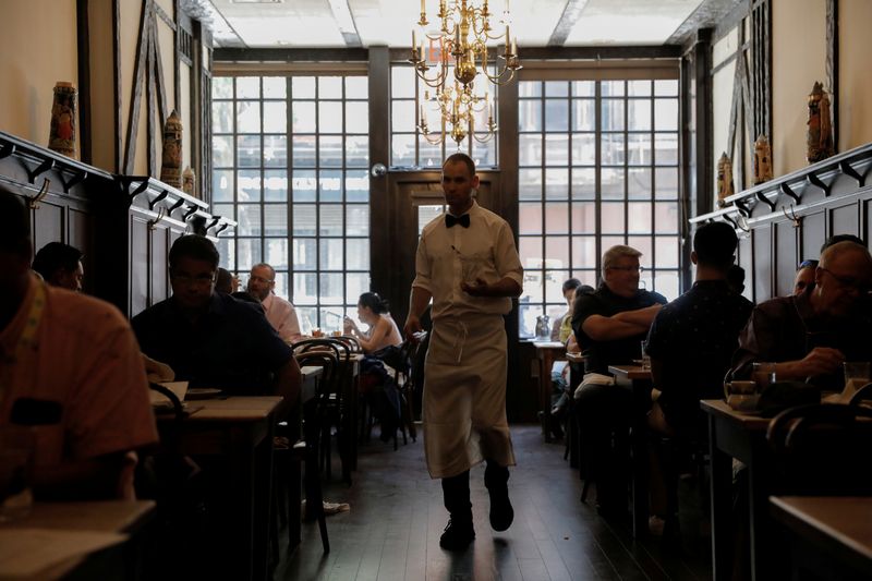 © Reuters. FILE PHOTO: A waiter walks among diners at a steak house in Brooklyn, New York City, U.S., August 12, 2021. REUTERS/Andrew Kelly/File Photo