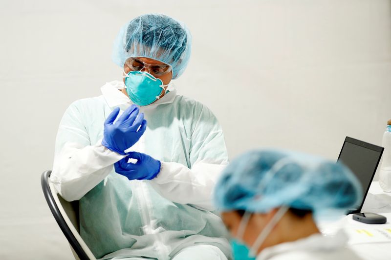 © Reuters. FILE PHOTO: A healthcare worker dons personal protective equipment (PPE) during the coronavirus disease (COVID-19) outbreak, in the Bronx borough of New York City, U.S., April 21, 2020. REUTERS/Lucas Jackson/File Photo