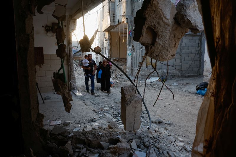 &copy; Reuters. Palestinos passam por edifícios danificados após ataque militar israelense, em Tulkarm, na Cisjordânia ocupada por Israeln12/09/2024nREUTERS/Mohammed Torokman