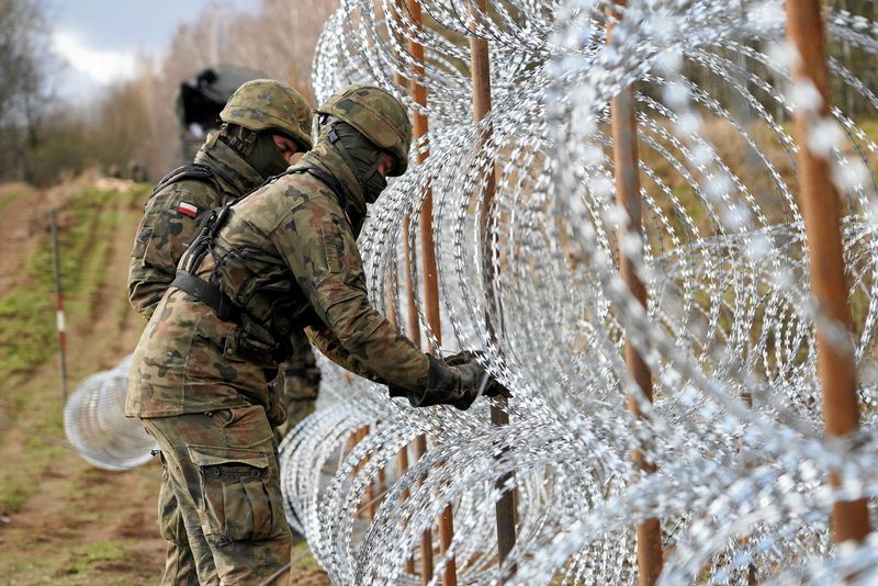 &copy; Reuters. FILE PHOTO: Soldiers build razor wire fence on Poland's border with Russia's exclave of Kaliningrad near Bolcie, Poland November 3, 2022. Arkadiusz Stankiewicz/Agencja Wyborcza.pl via REUTERS ATTENTION/File Photo