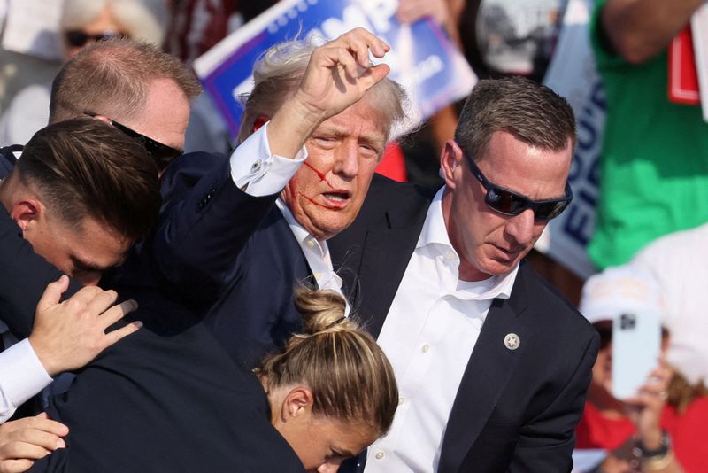 © Reuters. FILE PHOTO: Republican presidential candidate and former U.S. President Donald Trump gestures with a bloodied face as multiple shots rang out during a campaign rally at the Butler Farm Show in Butler, Pennsylvania, U.S., July 13, 2024. REUTERS/Brendan McDermid/File Photo