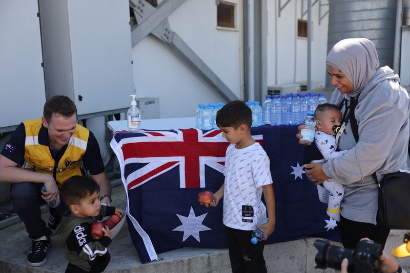 &copy; Reuters. An Australian official offers apples to children as Australian nationals, evacuated from Lebanon due to ongoing hostilities between Hezbollah and the Israeli forces, arrive at Larnaca International Airport, in Larnaca, Cyprus, October 5, 2024. REUTERS/Yia