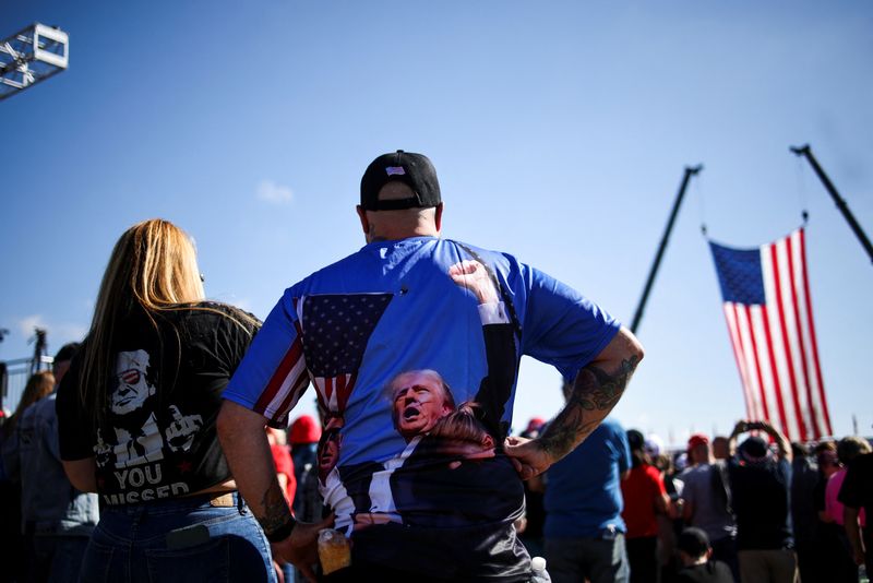 © Reuters. People wear shirts in support of Republican presidential nominee and former U.S. president Donald Trump, on the day Trump returns to the site of the July assassination attempt against him in Butler, Pennsylvania, U.S., October 5, 2024. REUTERS/Carlos Barria