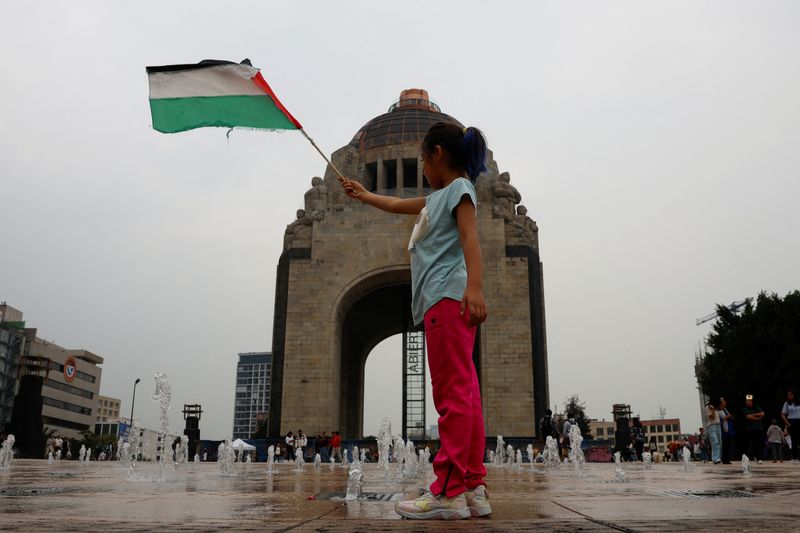 © Reuters. A girl holds up a Palestinian flag during a march ahead of the October 7 attack anniversary, amid the Israel-Hamas conflict, in Mexico City, Mexico, October 5, 2024. REUTERS/Daniel Becerril