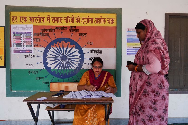 &copy; Reuters. A booth-level officer helps a woman verify her name in the voting list outside a polling station during the state assembly elections, in Karnal, in the northern state of Haryana, India, October 5, 2024. REUTERS/Bhawika Chhabra/File Photo