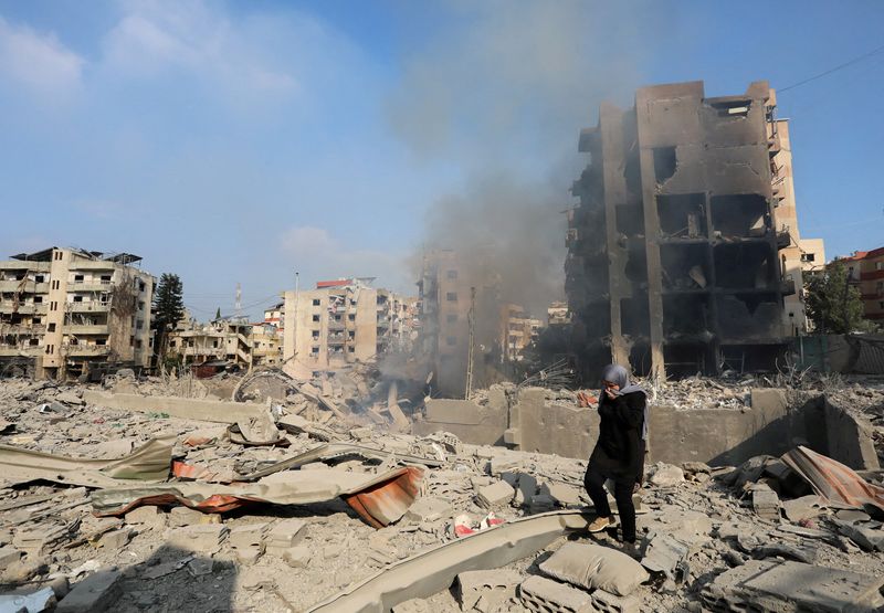 © Reuters. A woman walks on the rubble of a damaged site in the aftermath of Israeli strikes in Choueifat, amid the ongoing hostilities between Hezbollah and Israeli forces, Lebanon, October 6, 2024. REUTERS/Stringer