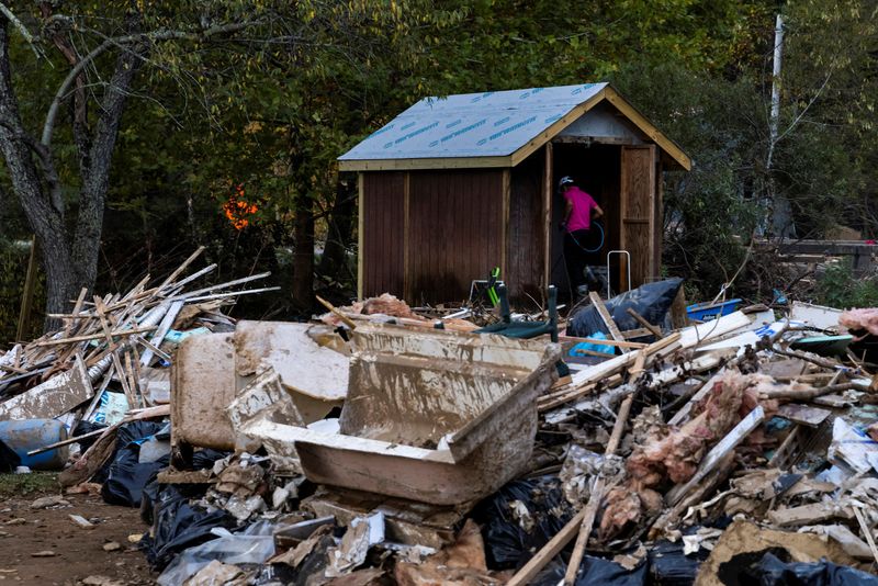 &copy; Reuters. A man cleans his shed covered with mud following the passing of Hurricane Helene, in Creston, North Carolina, U.S., October 5, 2024. REUTERS/Eduardo Munoz