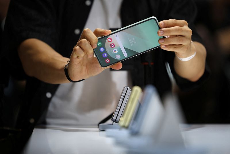 &copy; Reuters. FILE PHOTO: An attendee tries out a Samsung Electronics' Galaxy Z Flip 6 during its unveiling ceremony in Seoul, South Korea, July 8, 2024.  REUTERS/Kim Hong-Ji/File photo