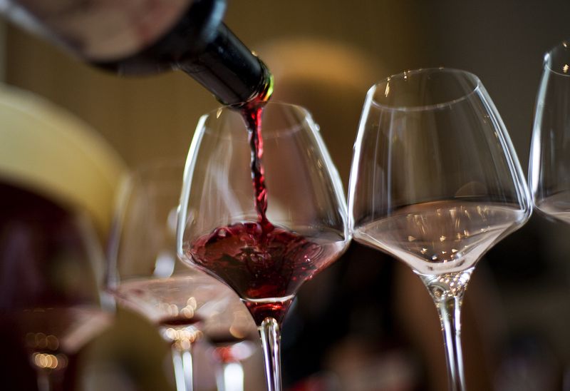 © Reuters. A waiter serves a glass of red wine in this illustration. REUTERS/Victor Fraile/File Photo