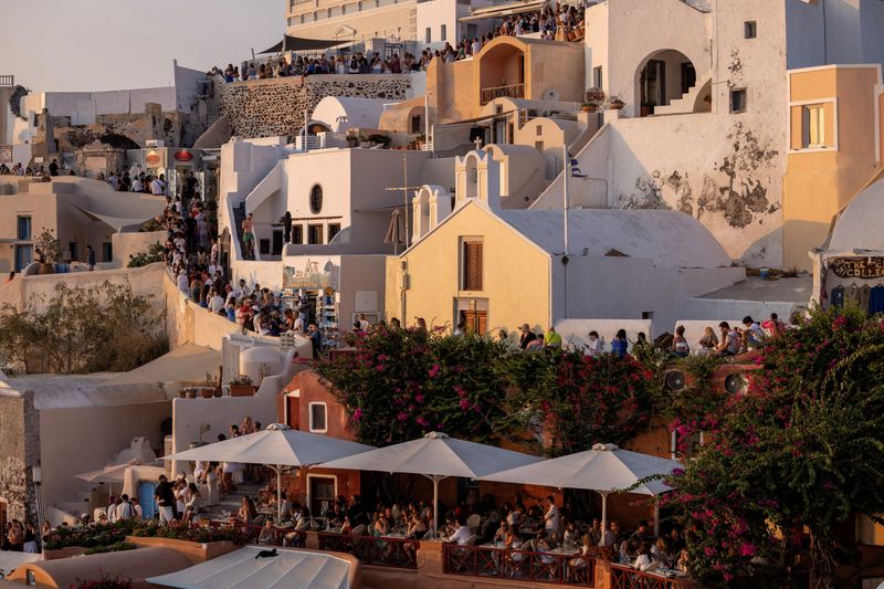 © Reuters. FILE PHOTO: Tourists wait to view Santorini’s famed sunset, on Santorini, Greece, July 25, 2024. REUTERS/Alkis Konstantinidis/File Photo