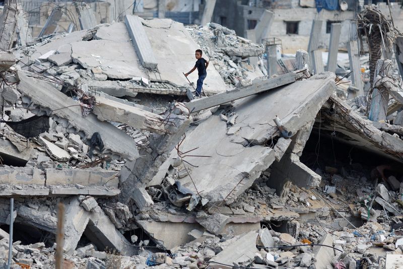 © Reuters. A Palestinian boy stands on the rubble of a house destroyed in Israel's military offensive, amid the ongoing conflict between Israel and Hamas, in Khan Younis in the southern Gaza Strip October 7, 2024. REUTERS/Mohammed Salem