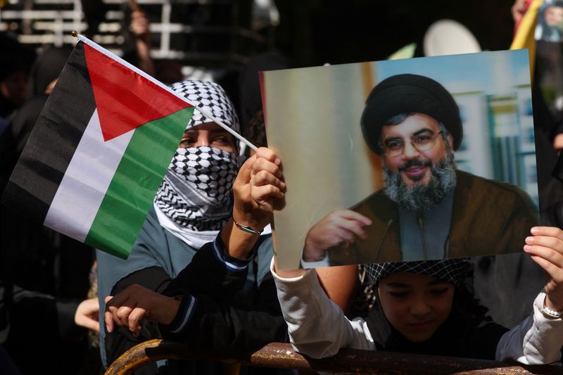 © Reuters. FILE PHOTO: Hezbollah supporters carry flags and banners depicting Hezbollah senior official Sayyed Hashem Safieddine during a protest in Beirut's southern suburbs, Lebanon October 18, 2023. REUTERS/Mohamed Azakir/File Photo