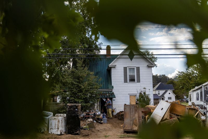 © Reuters. FILE PHOTO: Residents stand amid debris outside their home following the passing of Hurricane Helene, in Old Fort, North Carolina, U.S., October 4, 2024.  REUTERS/Eduardo Munoz/File Photo