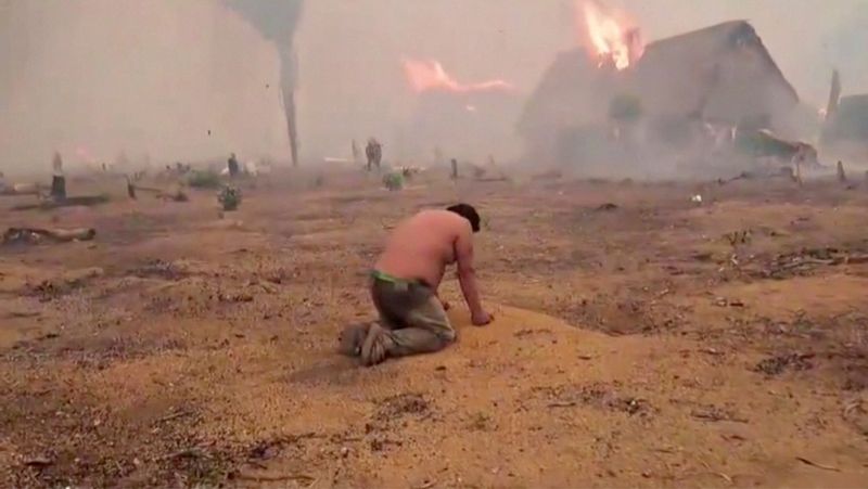 &copy; Reuters. A person kneels as he watches his home being consumed by fire in Riberalta, Beni, Bolivia, October 3, 2024 in this screengrab taken from a handout video.  Riberalta Government Handout/Handout via REUTERS